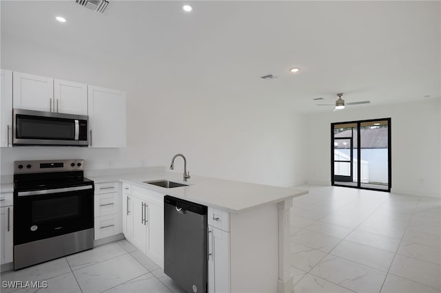 909-911 Homestead Rd S, Lehigh Acres, FL 33974 - kitchen with a peninsula, a ceiling fan, appliances with stainless steel finishes, marble finish floor, and a sink