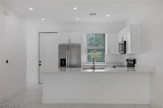 909-911 Homestead Rd S, Lehigh Acres, FL 33974 - kitchen with a peninsula, marble finish floor, light countertops, and stainless steel appliances