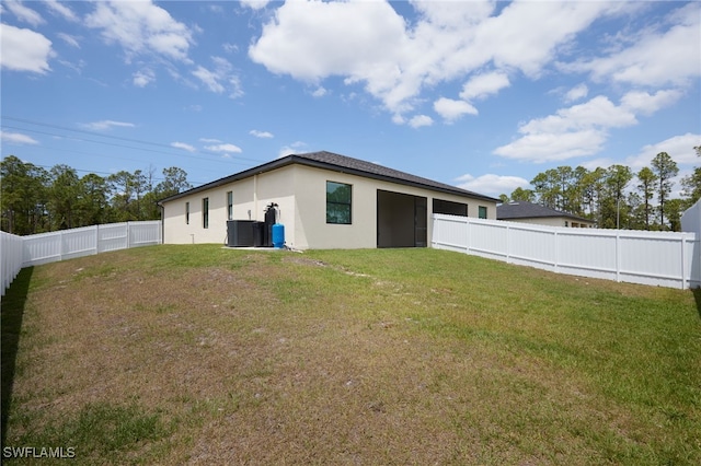 909-911 Homestead Rd S, Lehigh Acres, FL 33974 - back of house with a fenced backyard, cooling unit, a lawn, and stucco siding