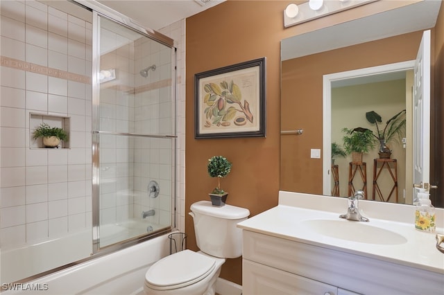 bathroom with toilet, vanity, and enclosed tub / shower combo