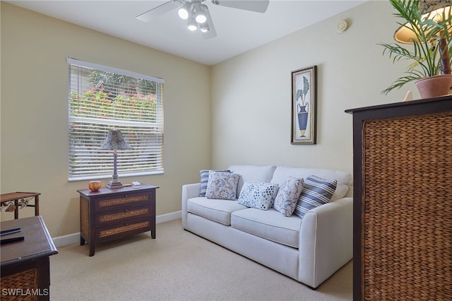 living room with ceiling fan, light colored carpet, and baseboards