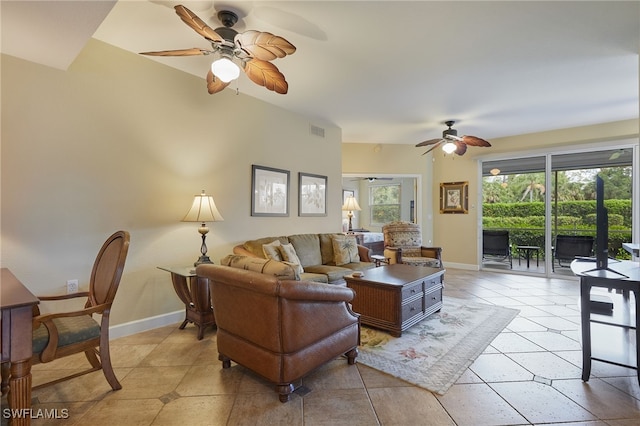 living room featuring visible vents, baseboards, a ceiling fan, and light tile patterned floors