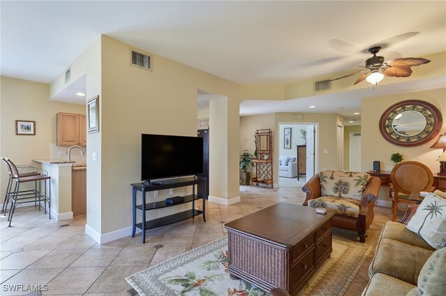 living room with ceiling fan, baseboards, and visible vents