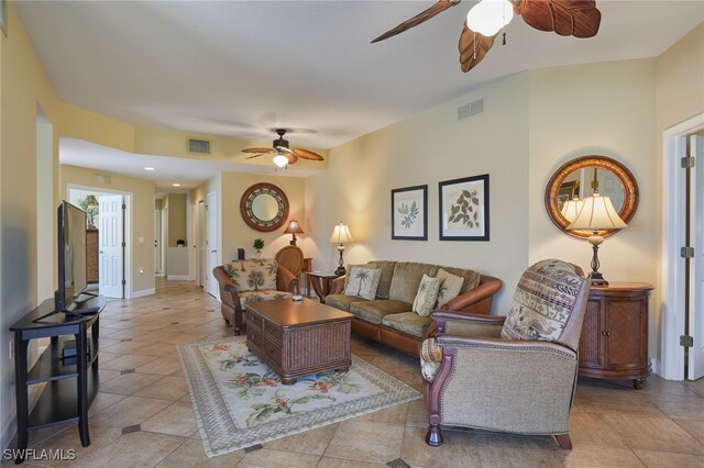 living room featuring ceiling fan, baseboards, visible vents, and light tile patterned floors