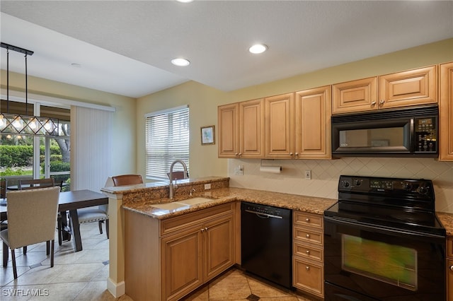 kitchen featuring a peninsula, light tile patterned floors, a wealth of natural light, black appliances, and a sink