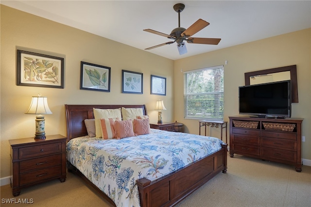 bedroom with light carpet, baseboards, and a ceiling fan