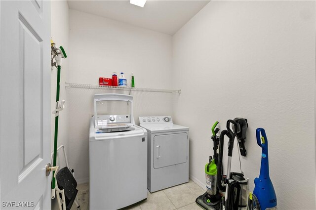 4834 Hampshire Ct Unit 207, Naples, FL 34112 - laundry area featuring light tile patterned floors, separate washer and dryer, and laundry area