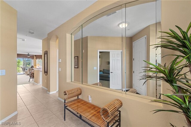 4834 Hampshire Ct Unit 207, Naples, FL 34112 - hallway featuring arched walkways, light tile patterned flooring, baseboards, and visible vents
