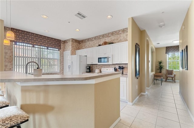 4834 Hampshire Ct Unit 207, Naples, FL 34112 - kitchen with light tile patterned floors, baseboards, white appliances, and visible vents