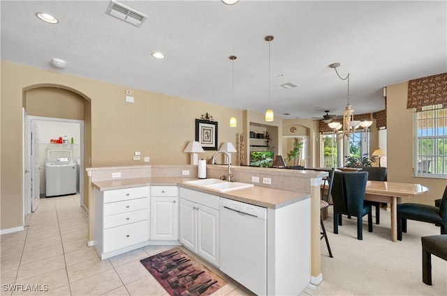 4834 Hampshire Ct Unit 207, Naples, FL 34112 - kitchen featuring washer / clothes dryer, white cabinets, visible vents, a sink, and white dishwasher