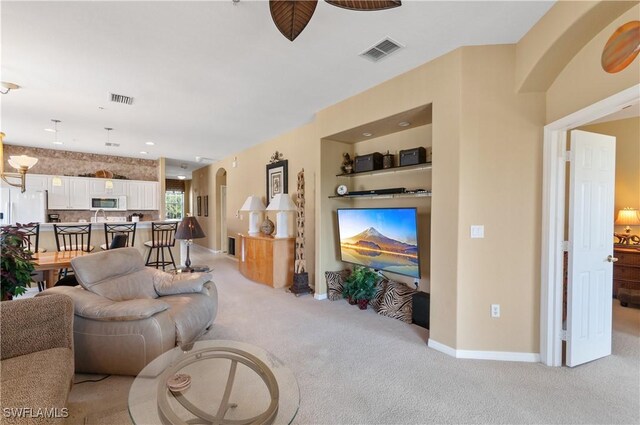 4834 Hampshire Ct Unit 207, Naples, FL 34112 - living room with light carpet, baseboards, visible vents, and arched walkways
