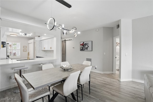 1220 Sarah Jean Cir Unit L103, Naples, FL 34110 - dining space with a barn door, light wood-style flooring, and baseboards