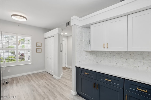 1220 Sarah Jean Cir Unit L103, Naples, FL 34110 - kitchen featuring white cabinets, light countertops, backsplash, light wood-style flooring, and blue cabinets