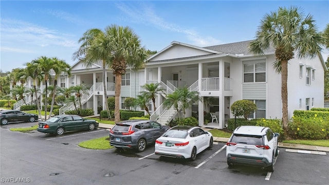 1220 Sarah Jean Cir Unit L103, Naples, FL 34110 - view of building exterior featuring stairs and uncovered parking