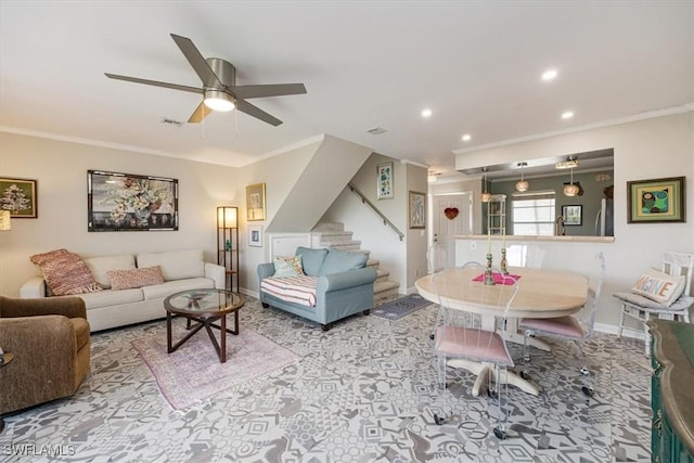 living room featuring ornamental molding, a ceiling fan, visible vents, and stairs