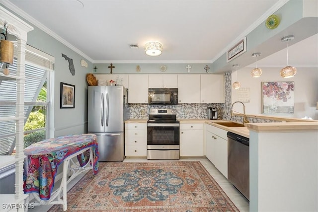 kitchen with tasteful backsplash, crown molding, appliances with stainless steel finishes, and a sink
