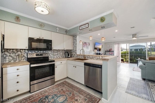 kitchen with a sink, open floor plan, light countertops, appliances with stainless steel finishes, and a peninsula