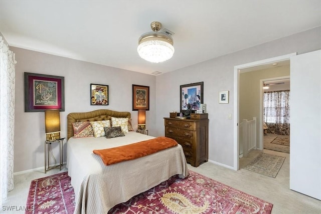bedroom featuring light carpet, baseboards, and an inviting chandelier