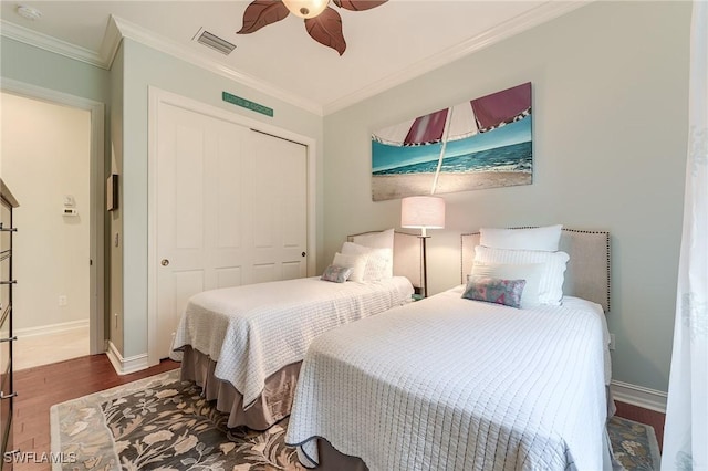 7699 Cottesmore Dr, Naples, FL 34113 - bedroom with visible vents, crown molding, wood finished floors, baseboards, and a closet