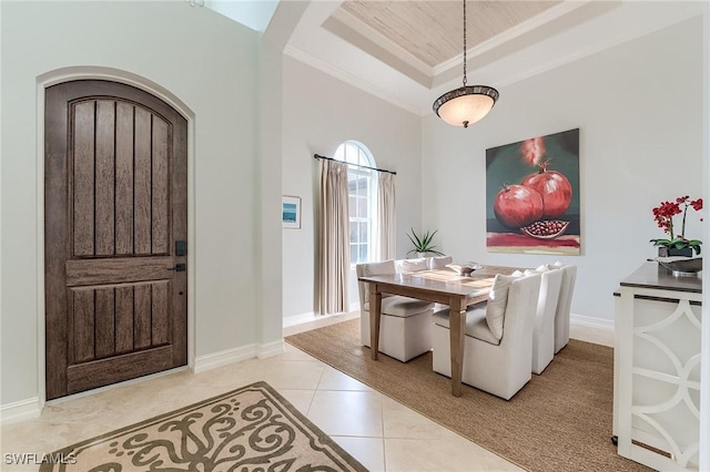 7699 Cottesmore Dr, Naples, FL 34113 - dining room with crown molding, arched walkways, tile patterned flooring, baseboards, and a tray ceiling