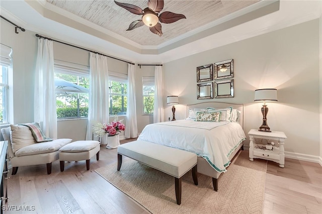 7699 Cottesmore Dr, Naples, FL 34113 - bedroom featuring crown molding, baseboards, a tray ceiling, and light wood finished floors
