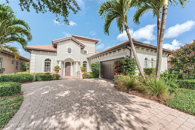 7699 Cottesmore Dr, Naples, FL 34113 - mediterranean / spanish-style house with stucco siding, decorative driveway, a tile roof, and a garage