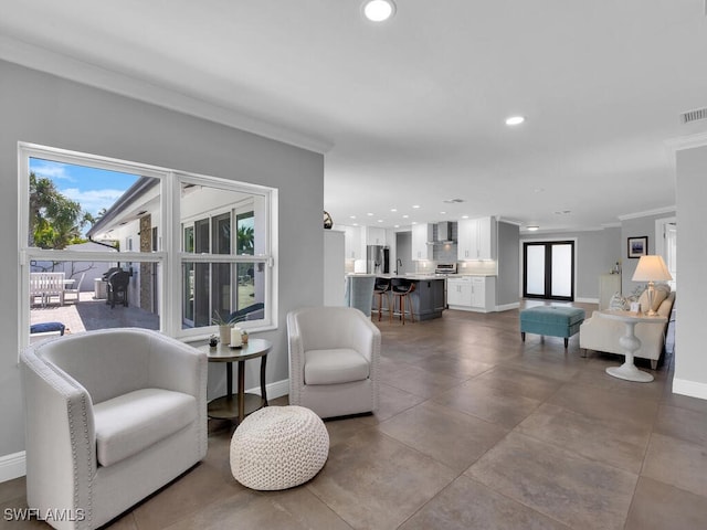 living area featuring baseboards, ornamental molding, and recessed lighting
