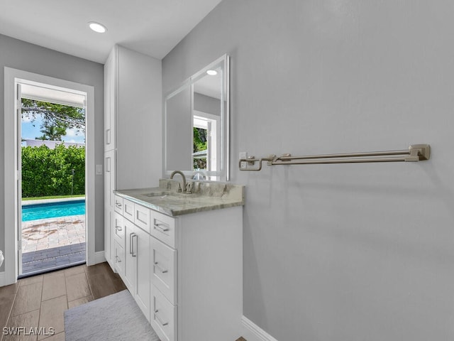 bathroom featuring baseboards, a healthy amount of sunlight, and vanity
