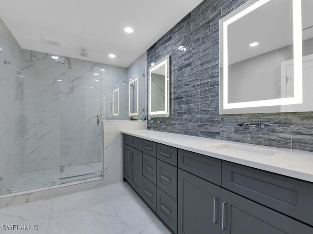 full bathroom featuring a sink, double vanity, a marble finish shower, marble finish floor, and tile walls