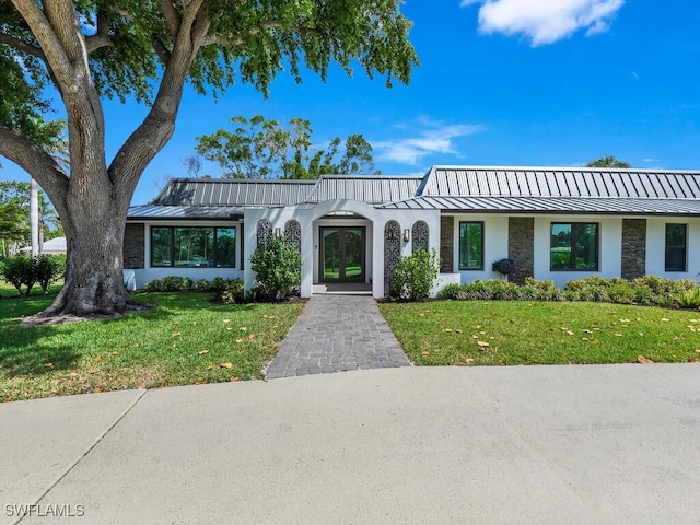 view of front of home featuring a standing seam roof, french doors, and metal roof