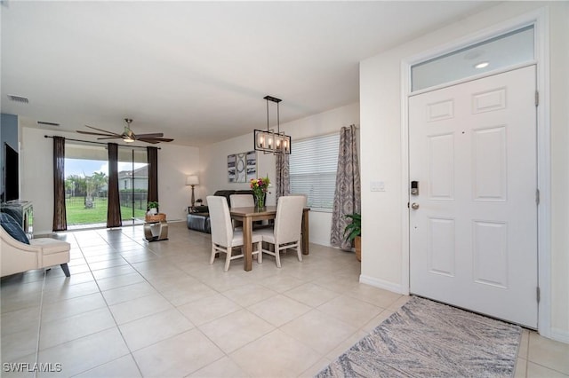 dining room with ceiling fan, light tile patterned floors, baseboards, and a chandelier