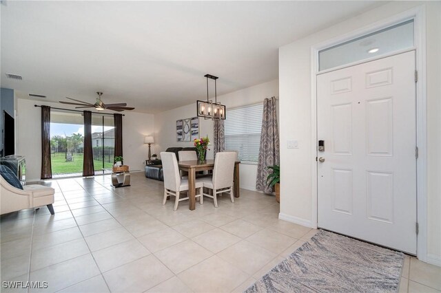 20018 Fiddlewood Ave, North Fort Myers, FL 33917 - dining room with ceiling fan, light tile patterned floors, baseboards, and a chandelier
