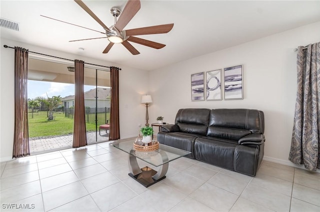 living area with ceiling fan, light tile patterned flooring, and baseboards