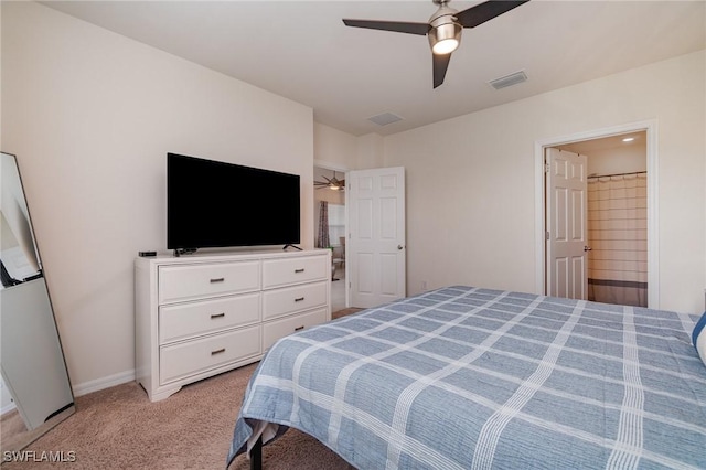 bedroom featuring light carpet, ceiling fan, baseboards, and ensuite bathroom