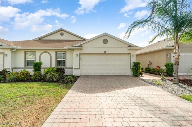 20018 Fiddlewood Ave, North Fort Myers, FL 33917 - single story home with decorative driveway, stucco siding, a garage, and a front lawn