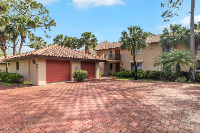 3207 Horse Carriage Way Unit 406, Naples, FL 34105 - mediterranean / spanish house featuring stucco siding, a tiled roof, a garage, and decorative driveway