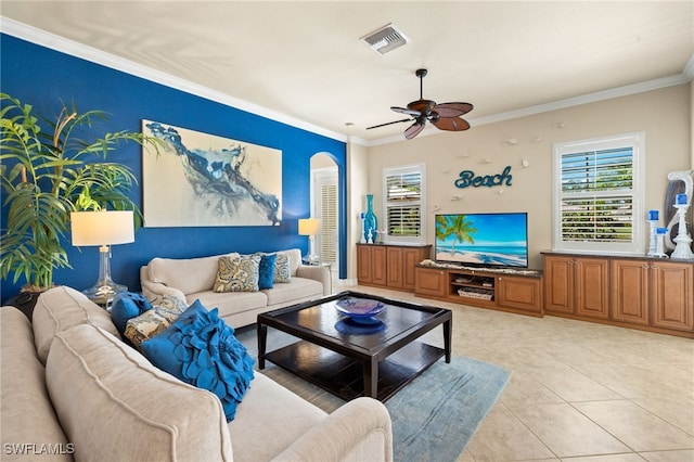 living room with crown molding, visible vents, ceiling fan, and light tile patterned floors