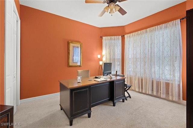 home office with ceiling fan, a wealth of natural light, light carpet, and baseboards