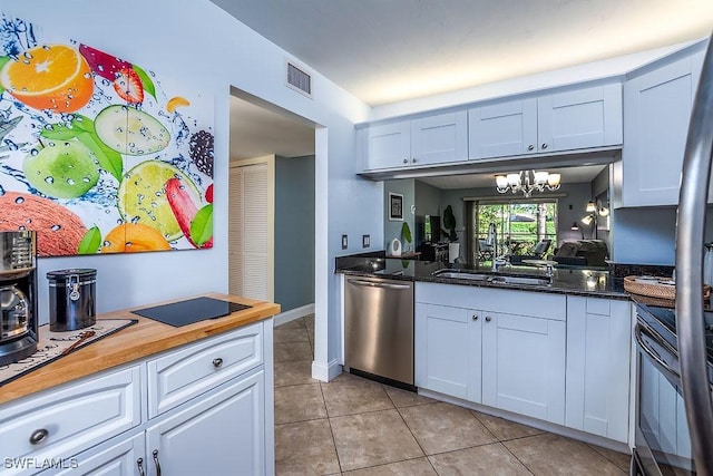 1702 Kings Lake Blvd Unit 103, Naples, FL 34112 - kitchen with stainless steel dishwasher, range, a sink, light tile patterned floors, and white cabinets