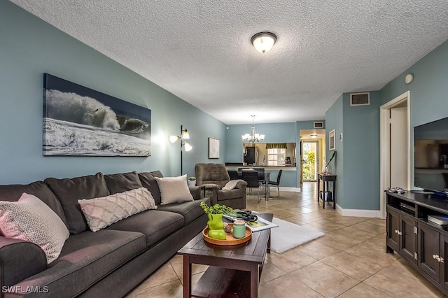 1702 Kings Lake Blvd Unit 103, Naples, FL 34112 - living area with a chandelier, light tile patterned floors, a textured ceiling, and baseboards