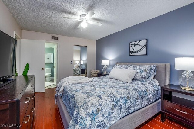1702 Kings Lake Blvd Unit 103, Naples, FL 34112 - bedroom with dark wood-style flooring, a textured ceiling, a ceiling fan, and ensuite bath