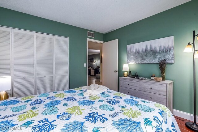 1702 Kings Lake Blvd Unit 103, Naples, FL 34112 - bedroom featuring a closet, wood finished floors, and baseboards