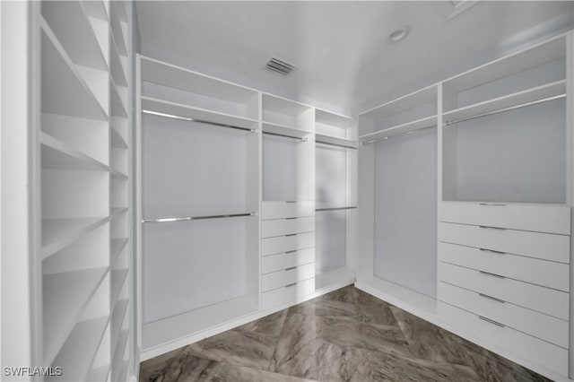 walk in closet with visible vents and marble finish floor