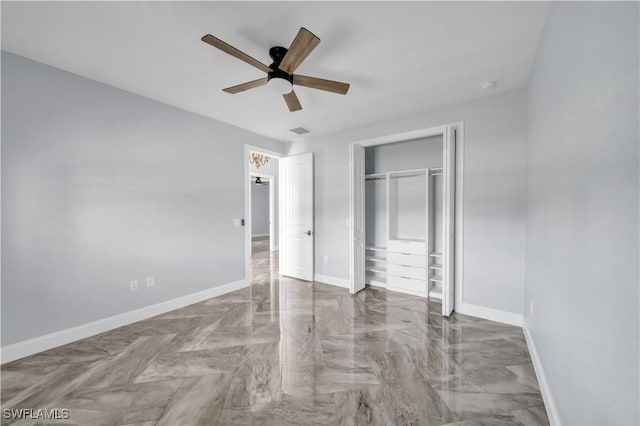 unfurnished bedroom with a closet, ceiling fan, marble finish floor, visible vents, and baseboards