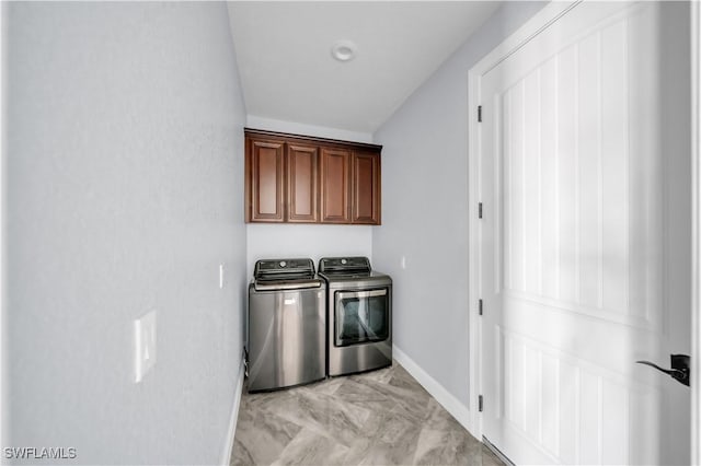 laundry room featuring baseboards, cabinet space, separate washer and dryer, and marble finish floor