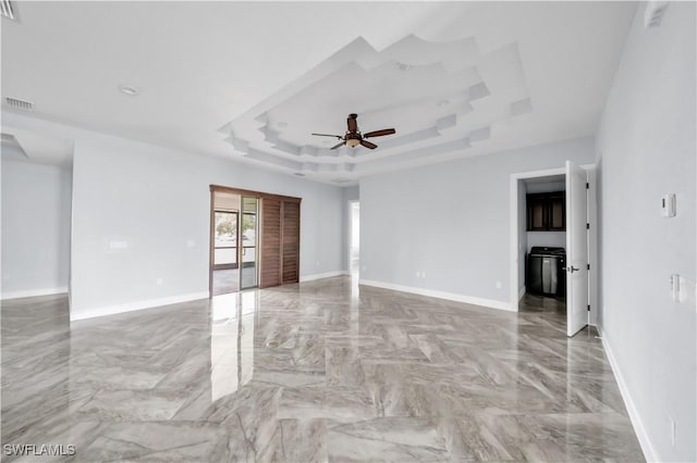 unfurnished room featuring a raised ceiling, ceiling fan, visible vents, baseboards, and marble finish floor