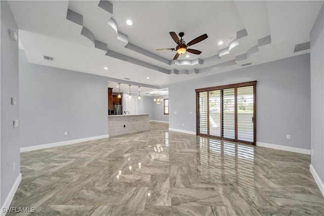 unfurnished living room with baseboards, visible vents, and a ceiling fan