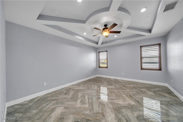 spare room with recessed lighting, a raised ceiling, a ceiling fan, visible vents, and baseboards