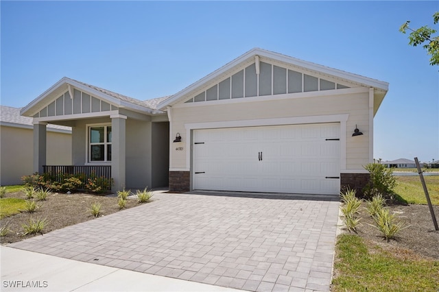 44385 Frontier Dr, Punta Gorda, FL 33982 - view of front of house with decorative driveway, a porch, stone siding, and board and batten siding