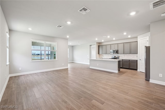 44385 Frontier Dr, Punta Gorda, FL 33982 - kitchen with appliances with stainless steel finishes, open floor plan, light wood-type flooring, gray cabinets, and recessed lighting
